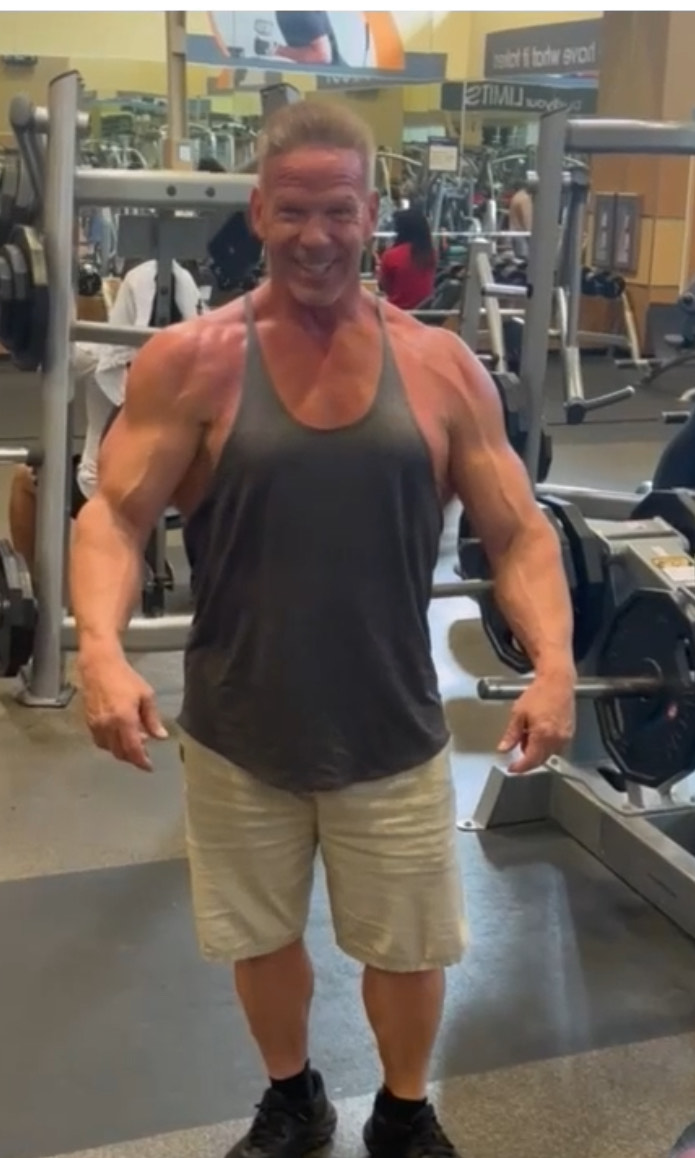 Coach Bill training in a black tank top at the gym